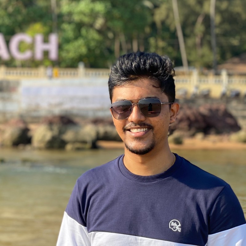 Rinold Simon, smiling outdoors at the beach